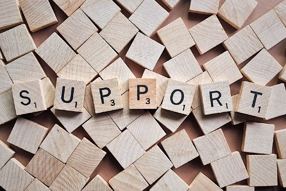 Scrabble tiles spell out "Support"